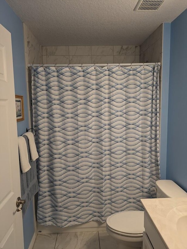 bathroom with vanity, curtained shower, a textured ceiling, and toilet