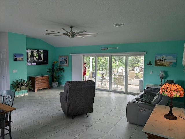 living room with lofted ceiling, ceiling fan, and a textured ceiling