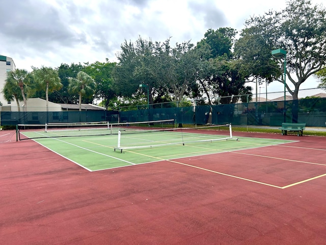 view of tennis court with community basketball court and fence