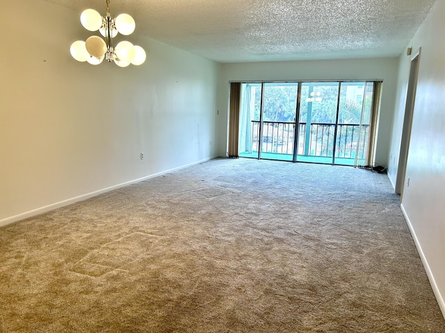 empty room featuring a notable chandelier, carpet floors, and a textured ceiling