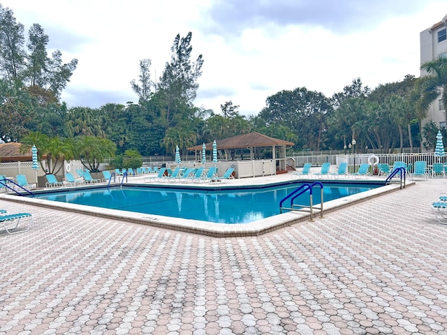 pool with a patio area and fence