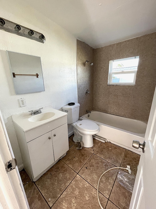 full bathroom featuring tile patterned floors, vanity, tiled shower / bath combo, and toilet