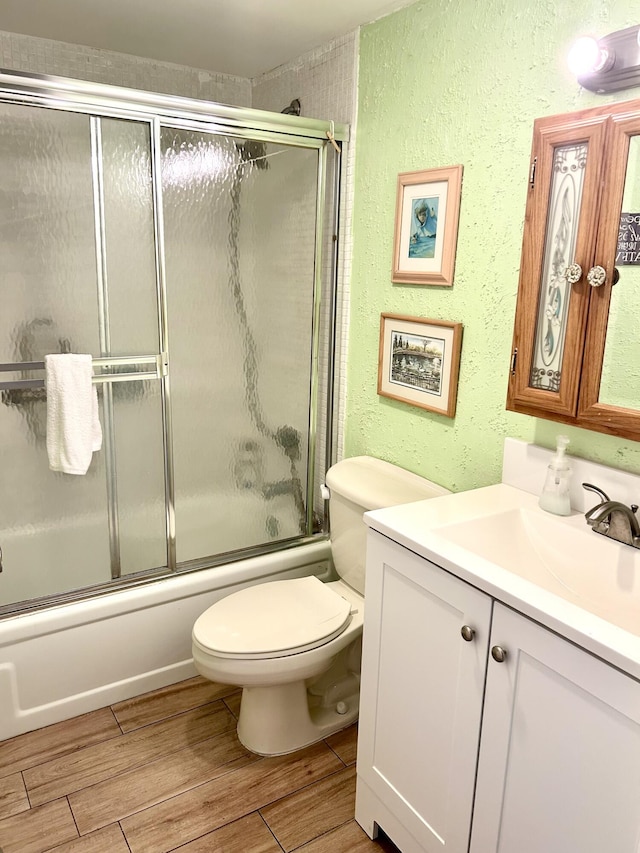 full bathroom with toilet, vanity, and shower / bath combination with glass door