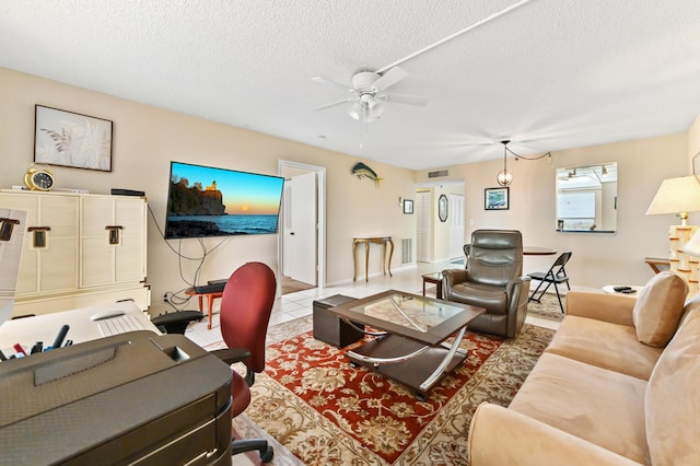 living room with light tile patterned floors, a textured ceiling, and ceiling fan