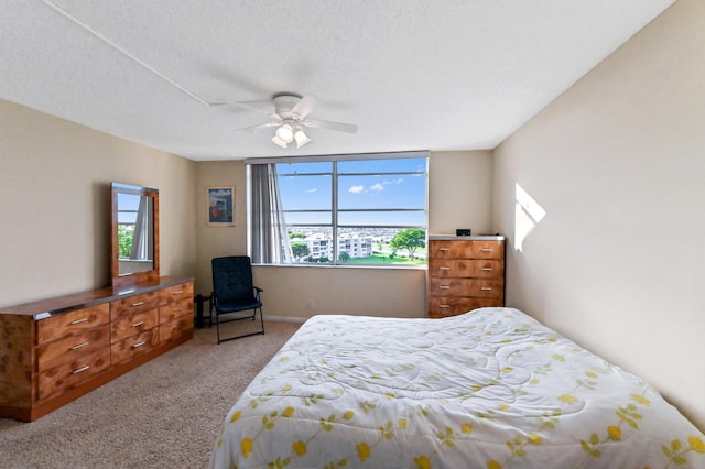 bedroom featuring a textured ceiling, ceiling fan, and light carpet