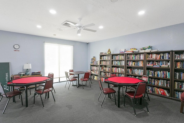 rec room featuring carpet flooring, ceiling fan, and a textured ceiling