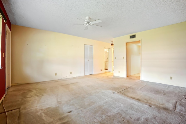 carpeted empty room featuring ceiling fan and a textured ceiling