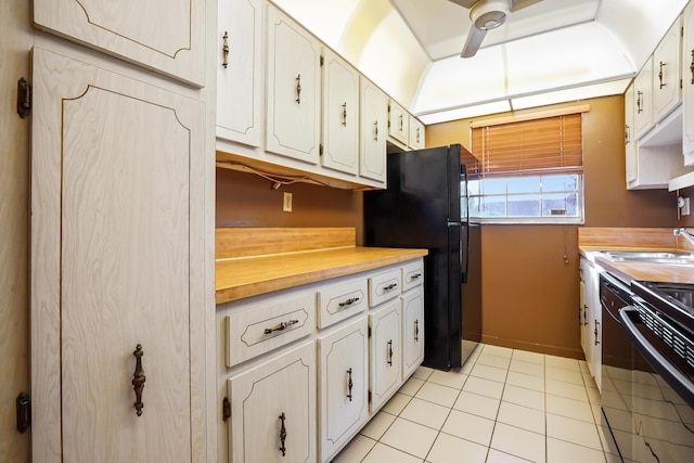 kitchen featuring white cabinets, black refrigerator, electric stove, ceiling fan, and light tile patterned flooring