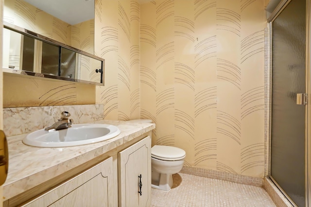 bathroom featuring tile patterned flooring, vanity, toilet, and an enclosed shower