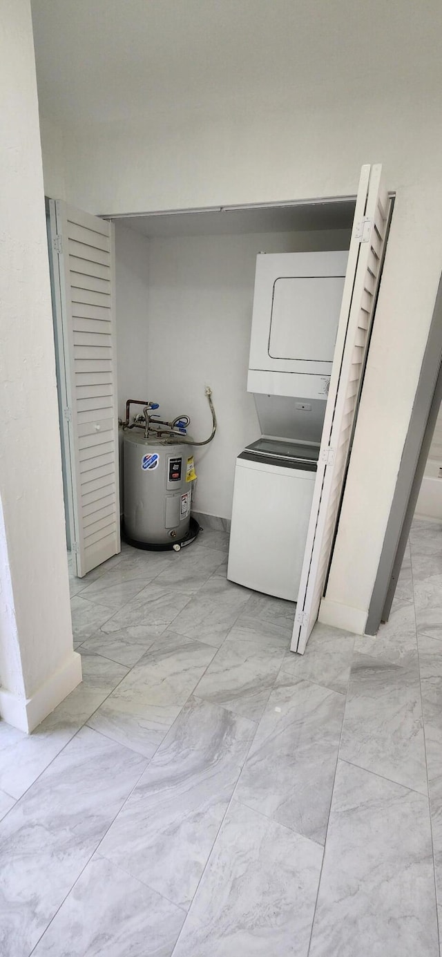 washroom with stacked washer and dryer and water heater