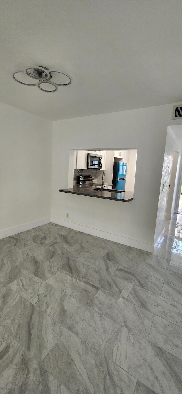 unfurnished living room featuring sink