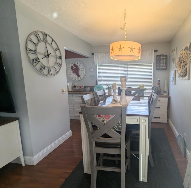 dining space featuring dark hardwood / wood-style flooring and a textured ceiling