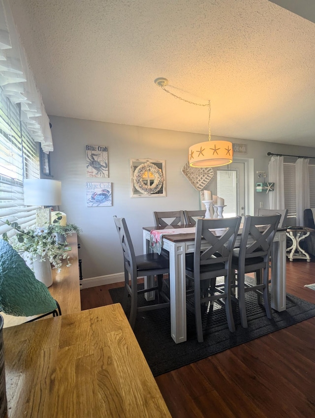 dining room featuring dark hardwood / wood-style floors and a textured ceiling