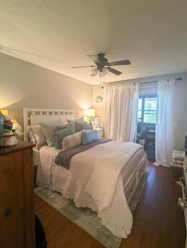 bedroom featuring a textured ceiling, ceiling fan, and dark hardwood / wood-style floors