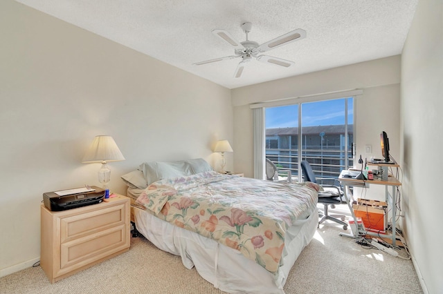 carpeted bedroom featuring ceiling fan and a textured ceiling