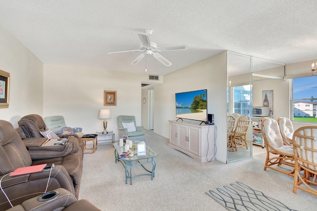 living room featuring ceiling fan with notable chandelier, a textured ceiling, and light carpet