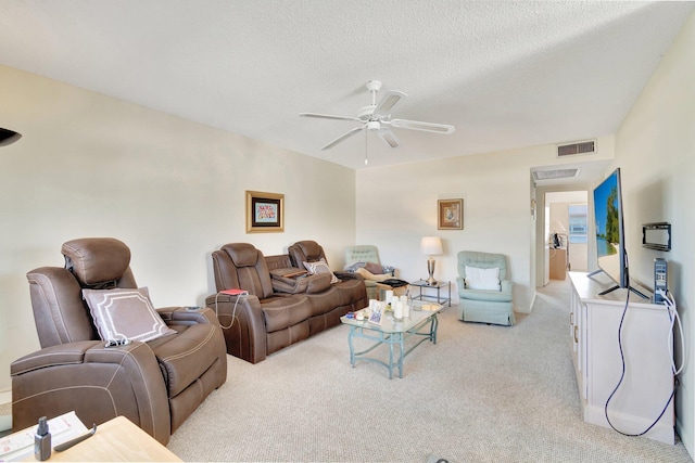 carpeted living room featuring a textured ceiling and ceiling fan