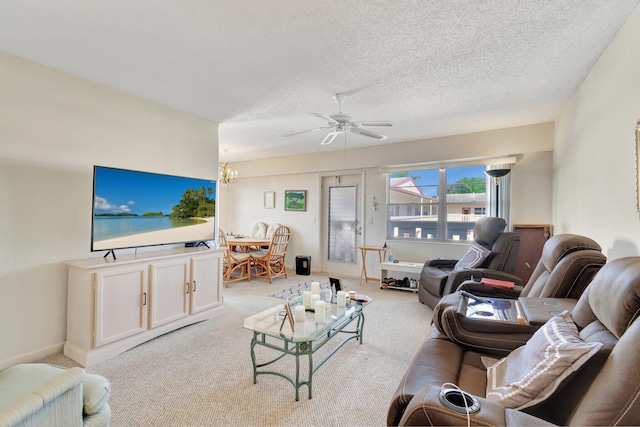 carpeted living room with ceiling fan with notable chandelier and a textured ceiling