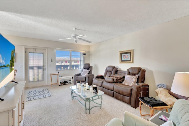 carpeted living room featuring a textured ceiling and ceiling fan