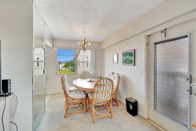 dining area featuring light carpet, a chandelier, and a textured ceiling