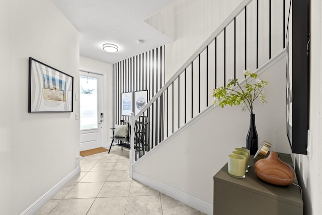 foyer entrance featuring light tile patterned floors and a textured ceiling