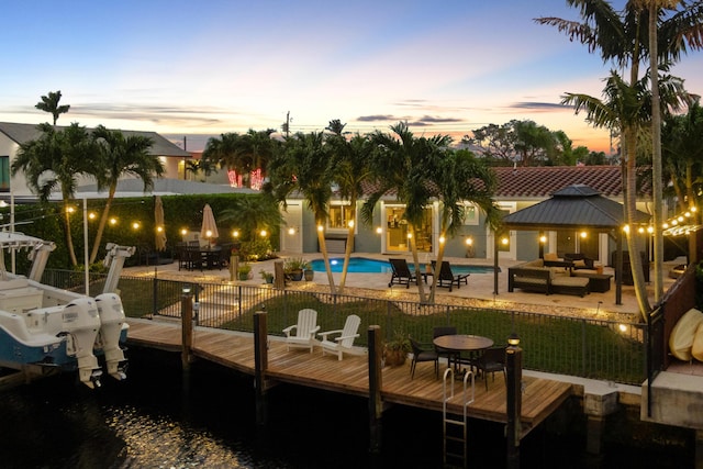 exterior space featuring a gazebo, a patio, a water view, an outdoor living space, and a boat dock