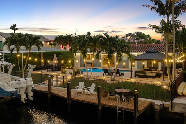 811 SE 4th Ave, Pompano Beach, FL 33060 - back of house at dusk featuring a patio area, outdoor lounge area, a gazebo, and a tiled roof