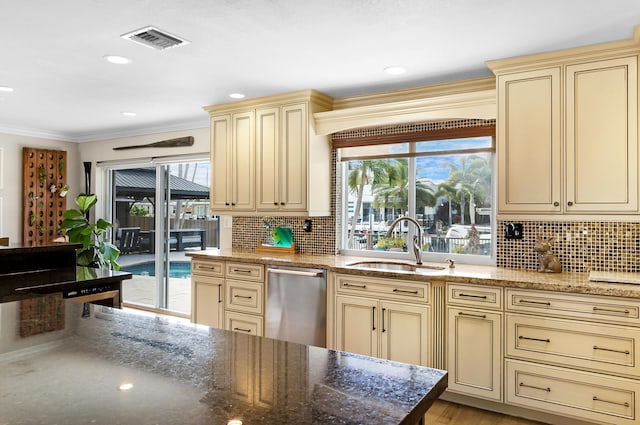 kitchen with sink, crown molding, dishwasher, tasteful backsplash, and cream cabinets