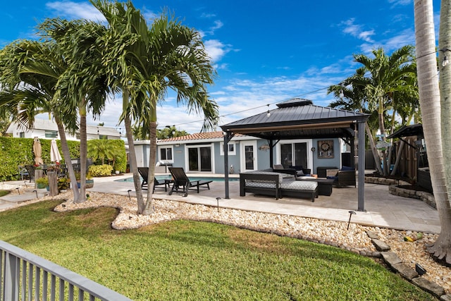 rear view of house with a lawn, outdoor lounge area, a fenced in pool, a gazebo, and a patio area