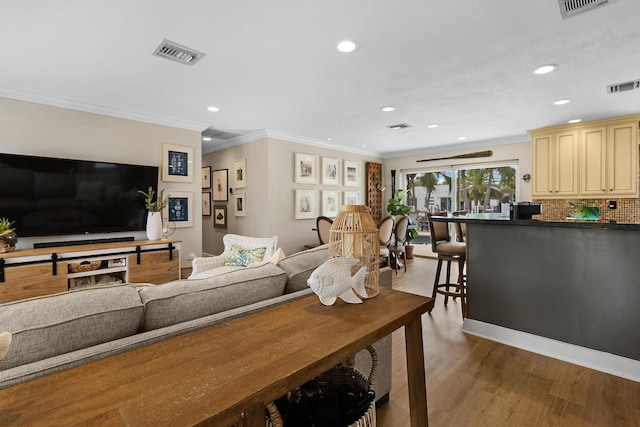 living room with crown molding and hardwood / wood-style floors