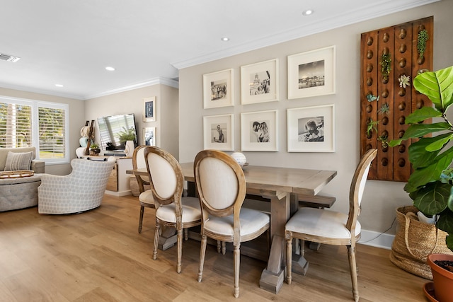 dining room featuring crown molding and light wood-type flooring