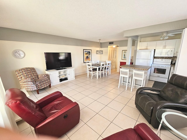 tiled living room with ceiling fan and a textured ceiling