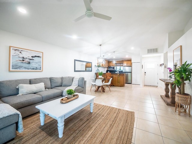 tiled living room with ceiling fan and vaulted ceiling