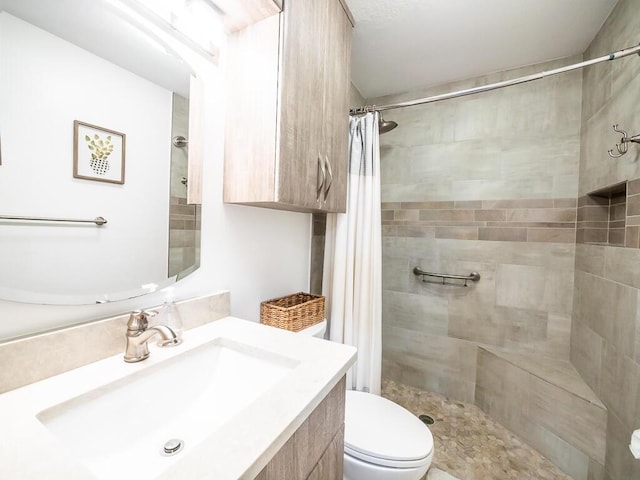 bathroom featuring curtained shower, vanity, and toilet