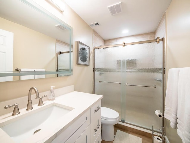 bathroom with vanity, toilet, a shower with door, and wood-type flooring