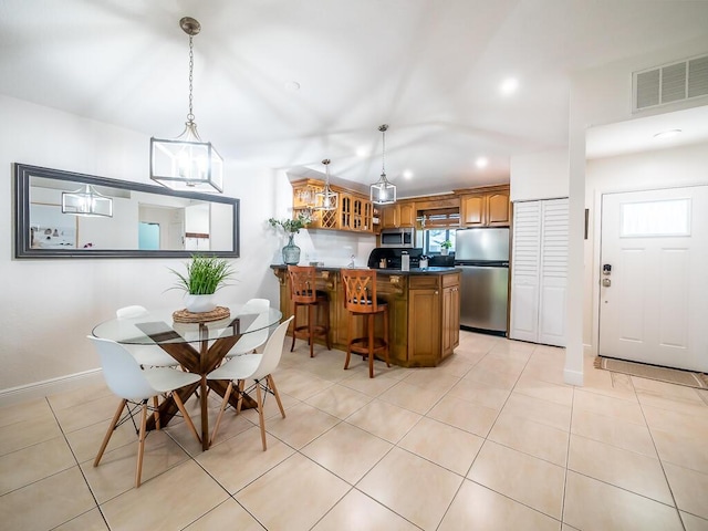 kitchen featuring kitchen peninsula, hanging light fixtures, light tile patterned flooring, and stainless steel appliances