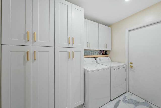 laundry area featuring washing machine and dryer and cabinets