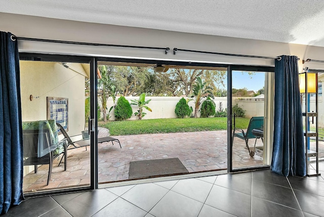 entryway featuring a textured ceiling and dark tile patterned floors