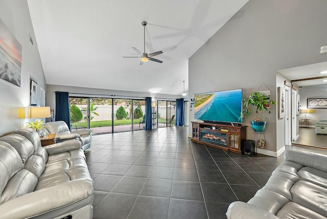 living room featuring ceiling fan, high vaulted ceiling, and dark tile patterned flooring