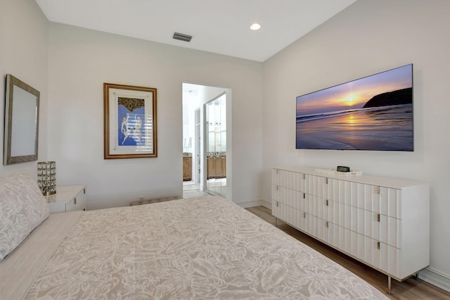 bedroom featuring hardwood / wood-style floors and ensuite bathroom