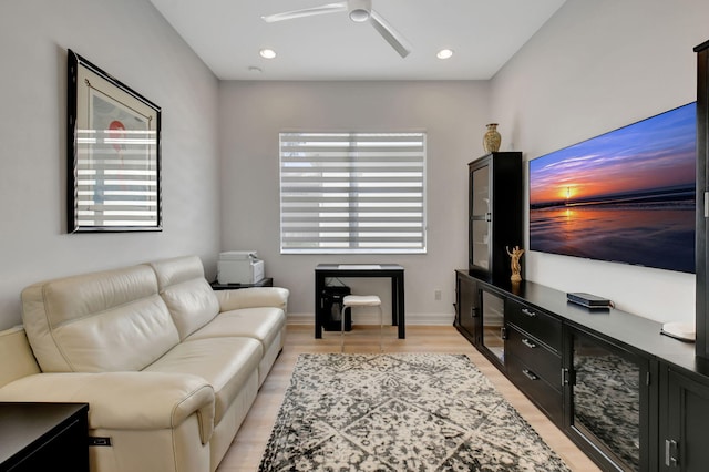 living room featuring light hardwood / wood-style floors, ceiling fan, and a healthy amount of sunlight