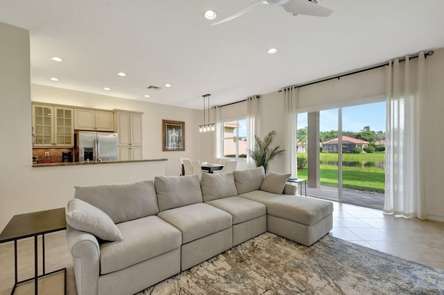 tiled living room with plenty of natural light and ceiling fan