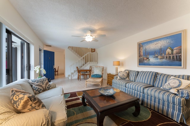 tiled living room featuring ceiling fan and a textured ceiling