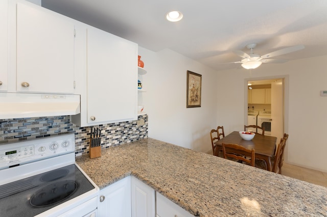 kitchen featuring washing machine and dryer, light stone counters, range hood, white range, and white cabinets