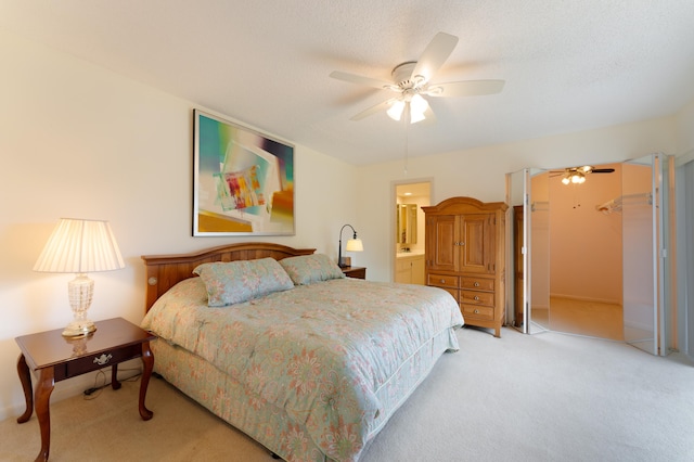 carpeted bedroom featuring a textured ceiling, connected bathroom, and ceiling fan