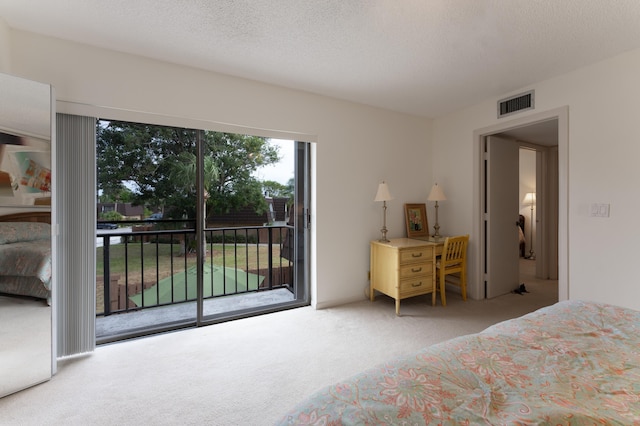 bedroom featuring access to exterior, a textured ceiling, and carpet flooring