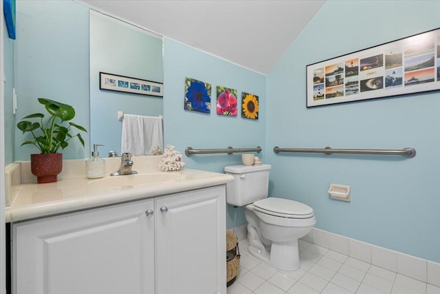 bathroom with tile patterned flooring, vanity, toilet, and lofted ceiling