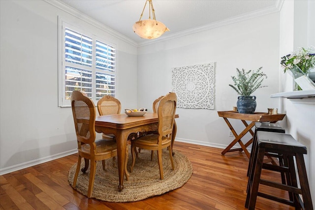 dining area featuring wood-type flooring and crown molding