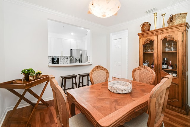 dining space featuring dark hardwood / wood-style floors and ornamental molding