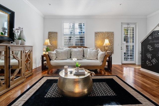 living room featuring hardwood / wood-style flooring, a healthy amount of sunlight, and crown molding